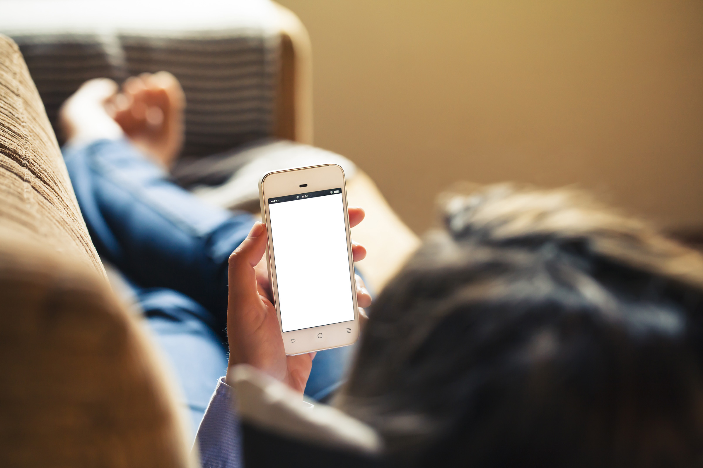 Person looking at their phone stretched out on couch