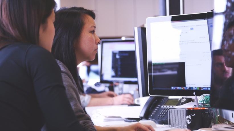 Two woman looking at a computer screen together